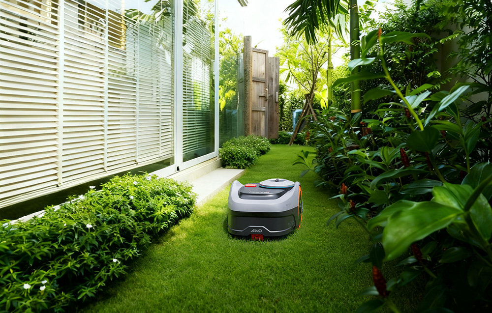 Robot koszący SEGWAY NAVIMOW i206E ogród trawnik robot kosi trawę w wąskim przejściu wokół rośliny biały płot innowacyjna funkcja Flexi Zero-Turn™ zawracanie robota w miejscu bez ryzyka uszkodzenia trawnika płynne manewrowanie równomiernie skoszona trawa i brak wydeptanych ścieżek