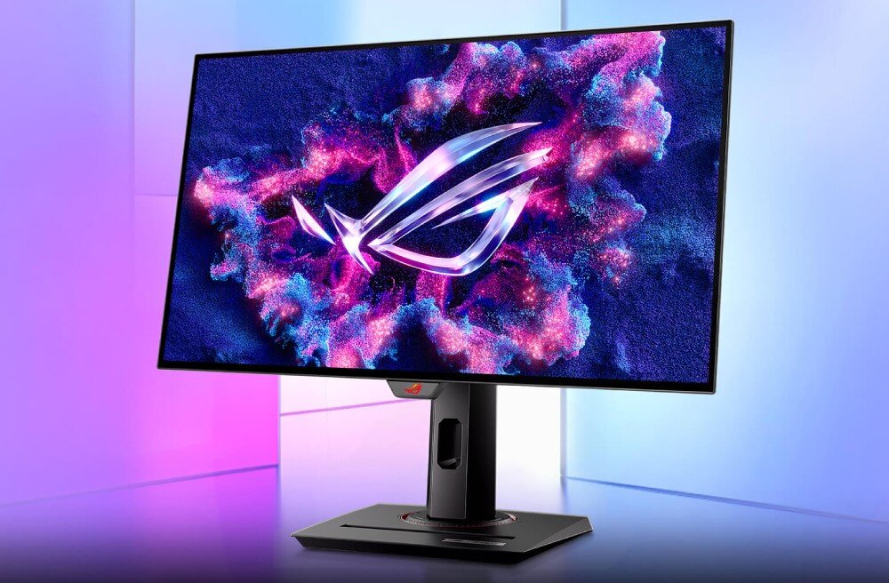 Monitor ASUS ROG Strix XG27AQDMG Monitor gamingowy z wyświetlonym kolorowym logo w odcieniach różu i błękitu, ustawiony na czarnej podstawie na tle gradientu fioletowo-niebieskiego, opis