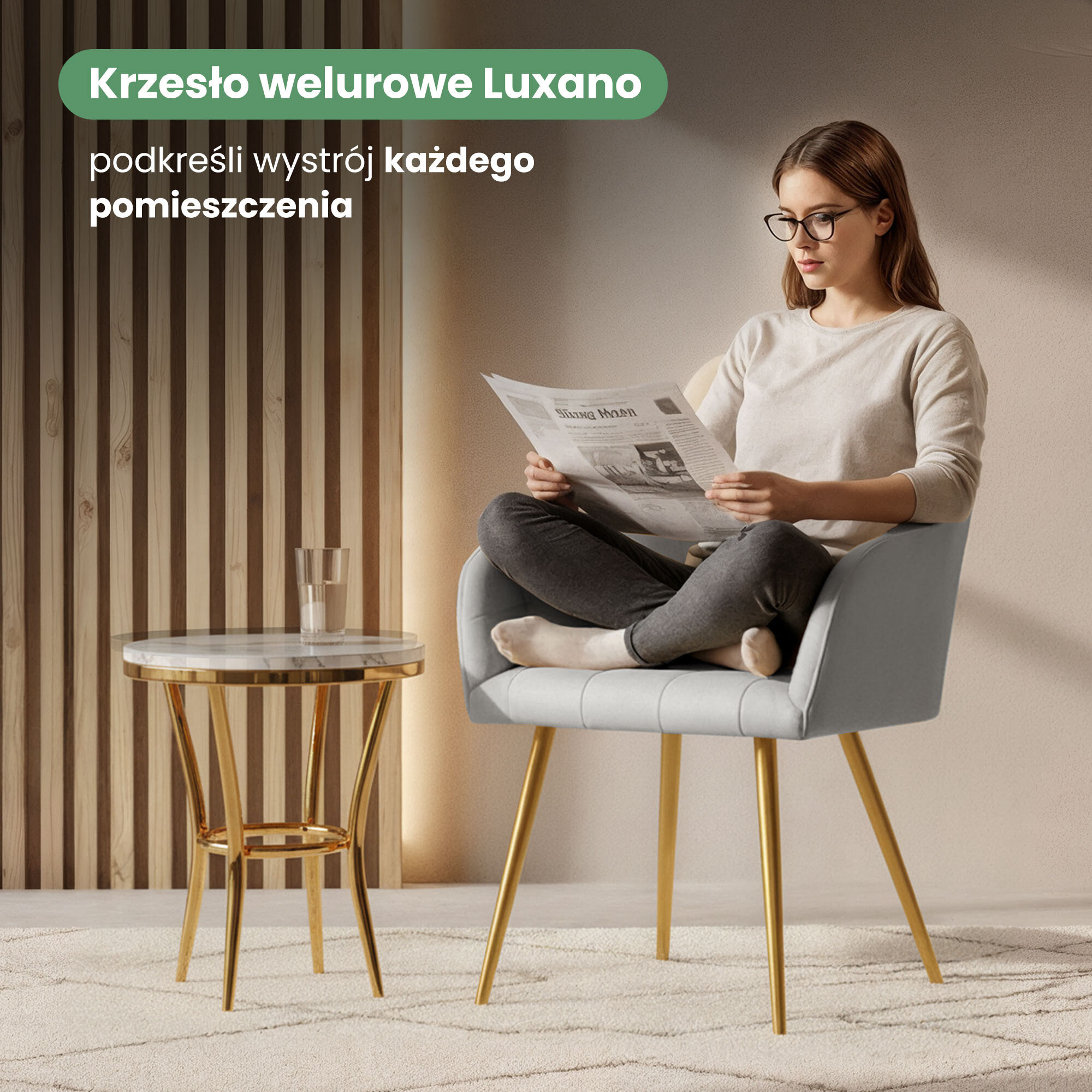 Osoba siedzi na szarym, tapicerowanym krześle z przeszyciami kwadratowymi i złotymi nogami, trzymając gazetę. Obok znajduje się stolik z marmurowym blatem i złotymi nogami, na którym stoi szklanka; na ścianie widoczny jest napis \'Krzesło welurowe Luxano podkreśli wystrój każdego pomieszczenia\'.