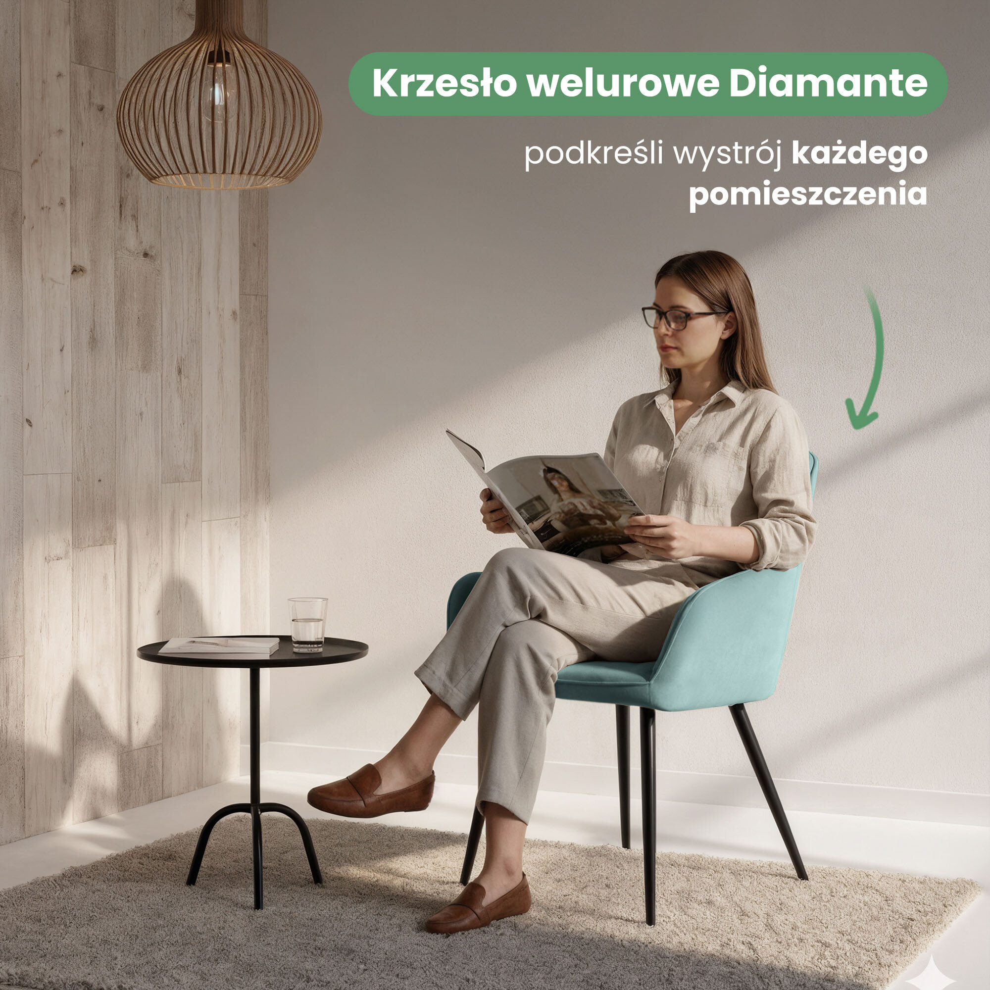 Osoba siedzi na turkusowym, welurowym krześle przy małym, czarnym stoliku z szklanką i czasopismem. Na obrazie widoczny jest tekst: \'Krzesło welurowe Diamante podkreśli wystrój każdego pomieszczenia\'.