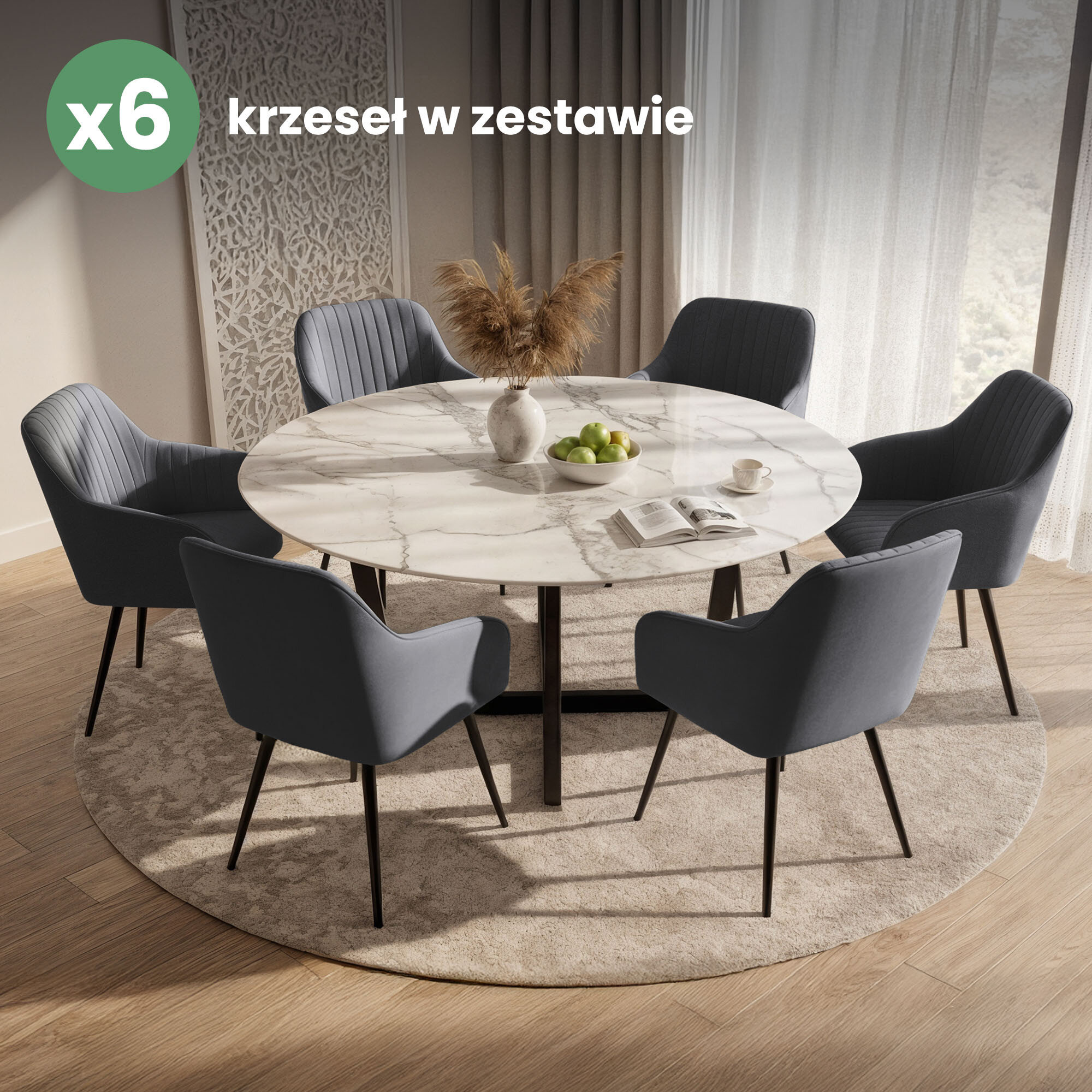 Na obrazie znajduje się zestaw sześciu welurowych krzeseł w ciemnym grafitowym kolorze z przeszyciami, ustawionych wokół okrągłego stołu z marmurowym blatem. Na stole znajduje się wazon z suszonymi trawami, miska z zielonymi jabłkami, filiżanka oraz otwarta książka.