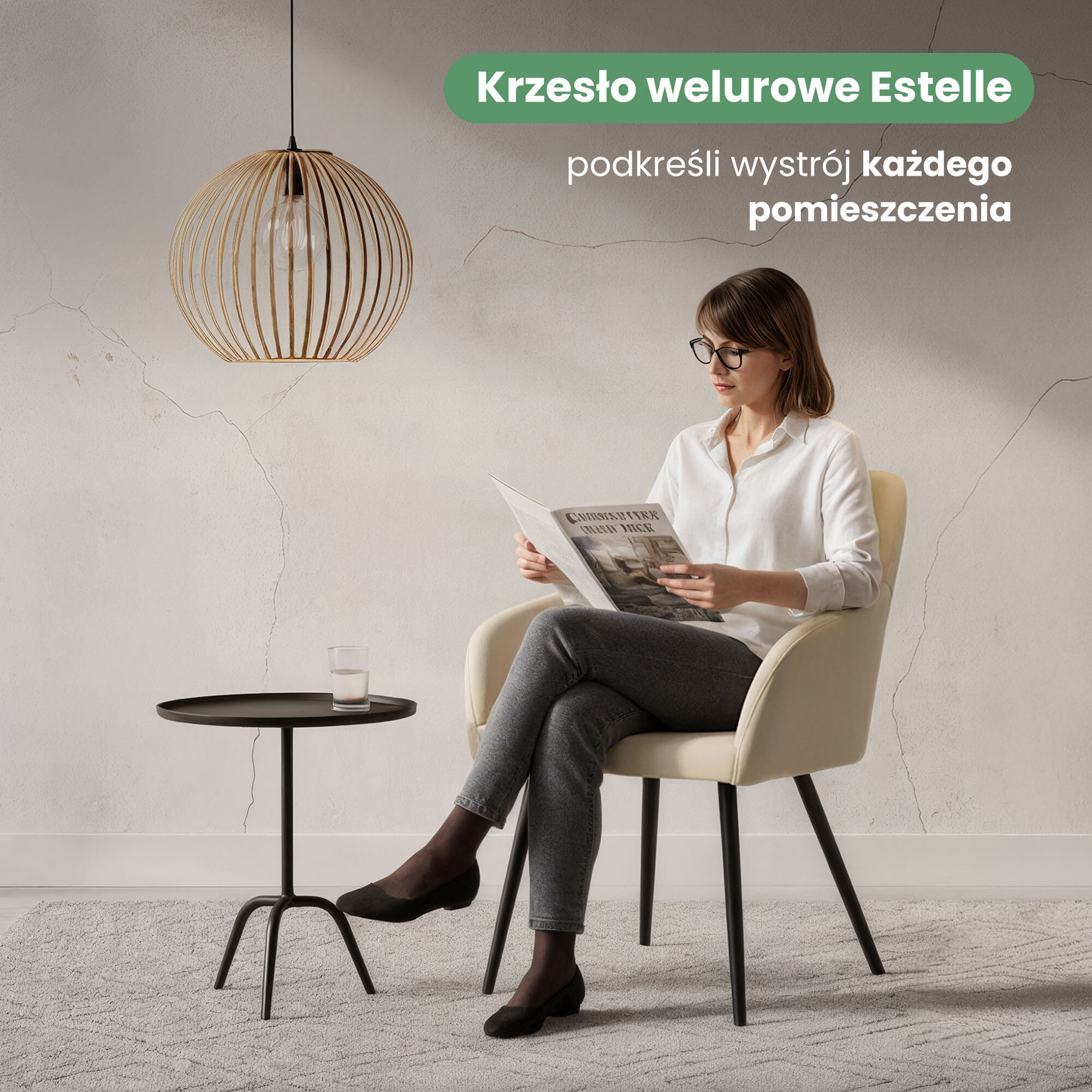 Osoba siedzi na beżowym, welurowym krześle z czarnymi nogami, obok znajduje się czarny stolik z szklanką. Na ścianie widoczny jest napis: \'Krzesło welurowe Estelle podkreśli wystrój każdego pomieszczenia\'.