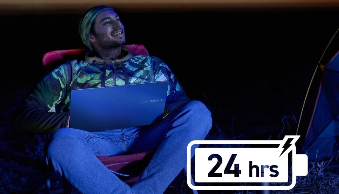 Mężczyzna używa laptopa MSI Prestige z baterią 24 hrs podczas pracy zdalnej przy namiocie o zmierzchu - Bateria do 30 godzin pracy na jednym ładowaniu  