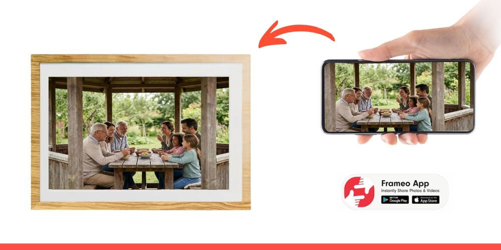 Obraz przedstawia cyfrową ramkę z wyświetlonym zdjęciem rodziny siedzącej przy stole w altanie oraz smartfon z tym samym zdjęciem. Widoczne jest logo \'Frameo App\' z ikonami Google Play i App Store.
