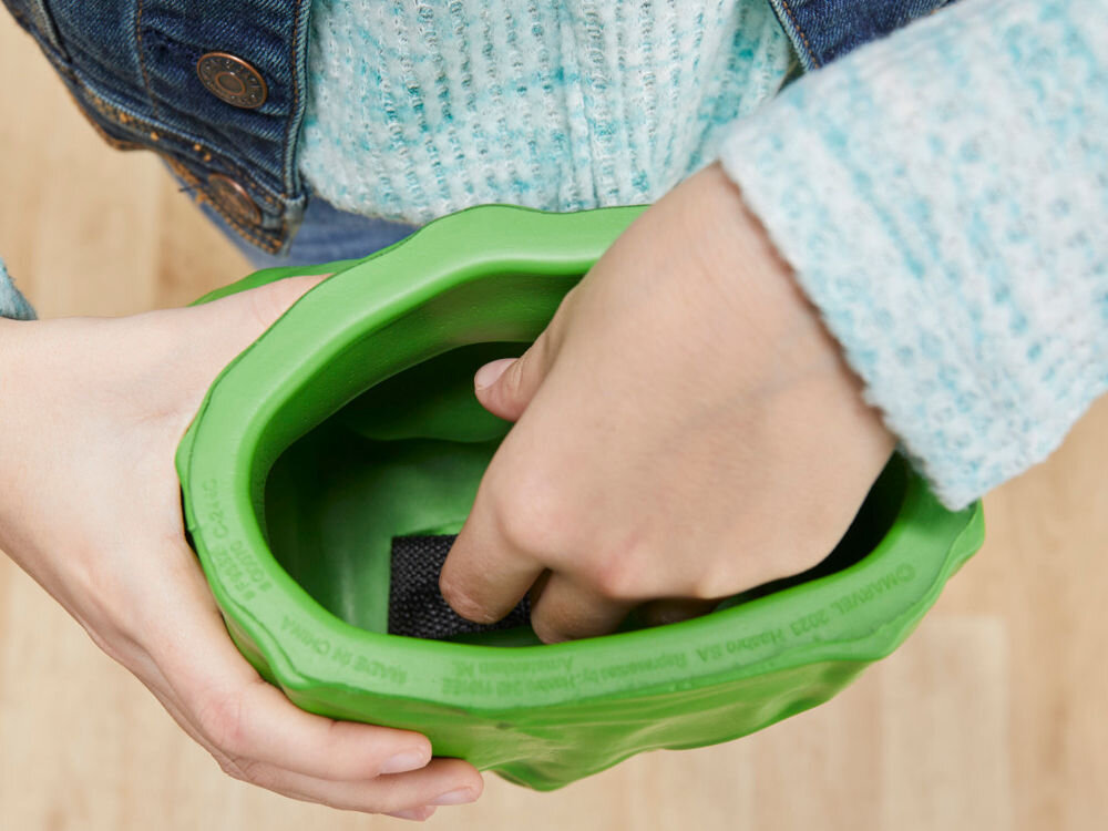 Rękawice HASBRO Marvel Avengers Gamma Smash Pięści Hulka F93325L0 Prezentacja wnętrza rękawicy Hulka. Dłoń dziecka trzyma się wewnętrznego uchwytu, co pozwala na stabilne sterowanie dużą, piankową pięścią podczas zabawy. Widoczny boczny profil zabawki z wyraźną rzeźbą mięśni.