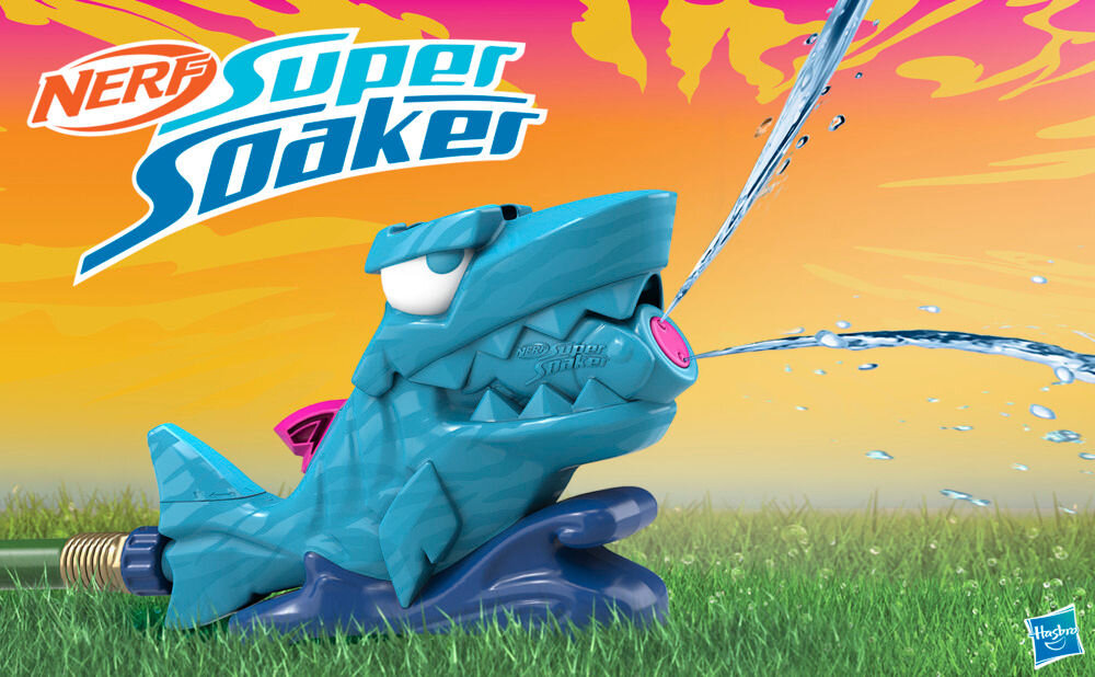 Wyrzutnia NERF Super Soaker Hop & Chomp G21485L0 Niebieska wyrzutnia wodna Nerf Super Soaker Hop & Chomp w kształcie głowy rekina, podłączona do węża ogrodowego na trawniku.