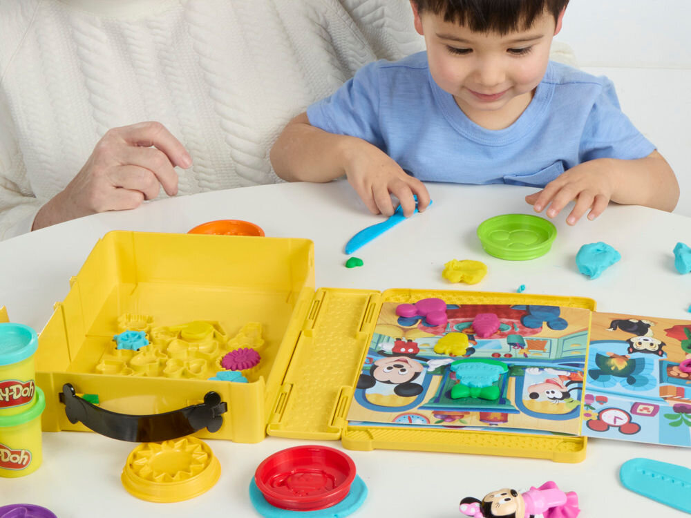 Ciastolina PLAY-DOH Disney Myszka Miki Ciastolinowe Opowieści G23245L0 Dziecko i dorosły wspólnie bawią się ciastoliną Play-Doh, wycinając kształty za pomocą niebieskiego nożyka i dopasowując kolorowe elementy do ilustracji z Myszką Miki.
