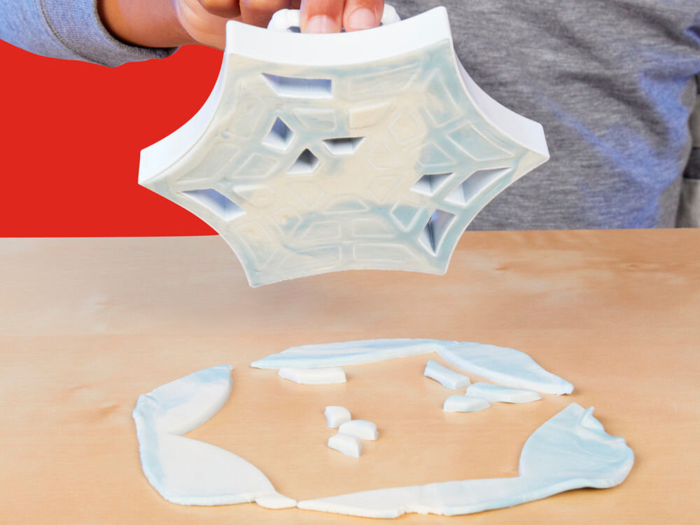 Ciastolina PLAY-DOH Marvel Spider-Man F98275L0 Dłonie dziecka używające turkusowej, dwuczęściowej foremki Play-Doh do formowania babeczki z różowej ciastoliny. Babeczka posiada dekoracyjny wierzch z motywem kokardy Myszki Minnie.