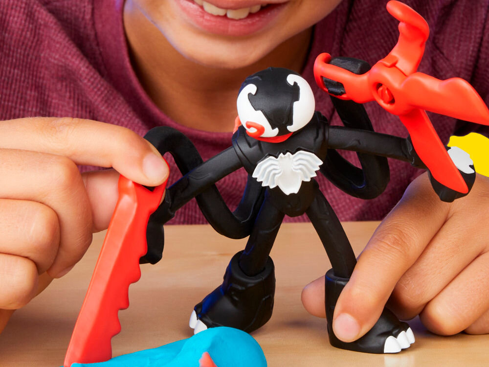 Ciastolina PLAY-DOH Marvel Spider-Man F98275L0 Zbliżenie na palce dziecka otwierające żółty pojemnik z masą plastyczną Play-Doh. Widoczna fioletowa pokrywka z wytłoczonym logo marki, co podkreśla łatwość użytkowania przez małe dzieci.