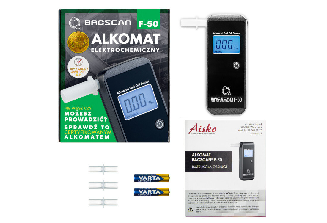 Na obrazie znajduje się alkomat BACSCAN F-50 z wyświetlaczem, opakowanie z napisem \'ALKOMAT ELEKTROCHEMICZNY\', instrukcja obsługi oraz dwie baterie VARTA. Widoczne są również trzy ustniki do alkomatu.