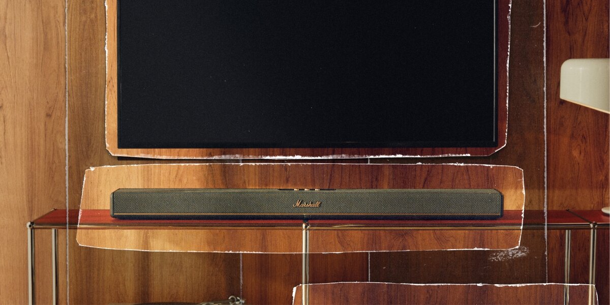 Soundbar MARSHALL Heston 60 domowe kino mocne brzmienie Dolby Atmos elegancki czarny design, soundbar stojący na stoliku pod zawieszonym telewizorem