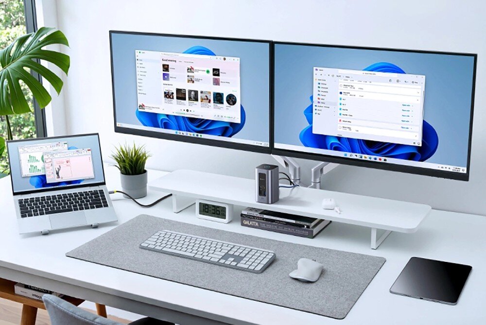 Stacja dokująca BASEUS NU1 Air Spacemate Stanowisko pracy z dwoma monitorami wyświetlającymi interfejs systemu Windows, laptopem po lewej stronie oraz stacją dokującą umieszczoną pomiędzy monitorami