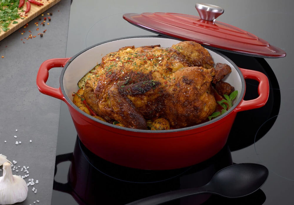 Brytfanna MG HOME Infinito 28 cm do każdej kuchni brytfanna czerwona pokrywka uchylona stoi na płycie mięso w środku naczynia 