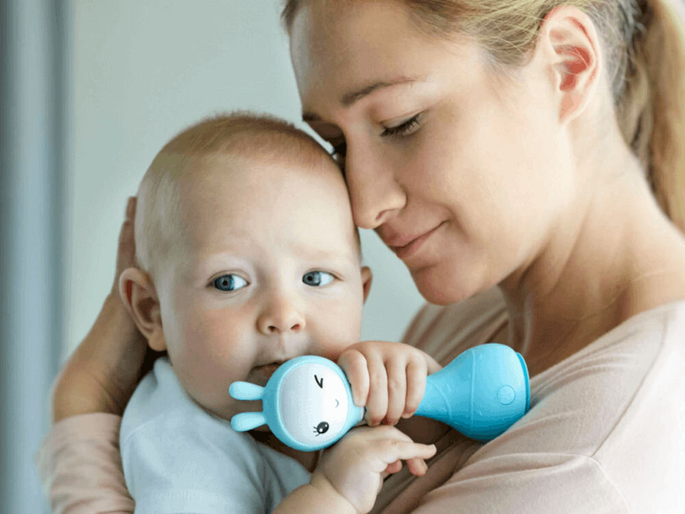 Zabawka edukacyjna ALILO Smarty Bunny R1 Niebieski kompaktowy i wygodny rozmiar zaprojektowany tak, aby
					dobrze pasował do małych rączek dzieci wymiary ok. 16 x 5,5 x 6,5 cm, dziecko na rękach mamy trzymające zabawkę