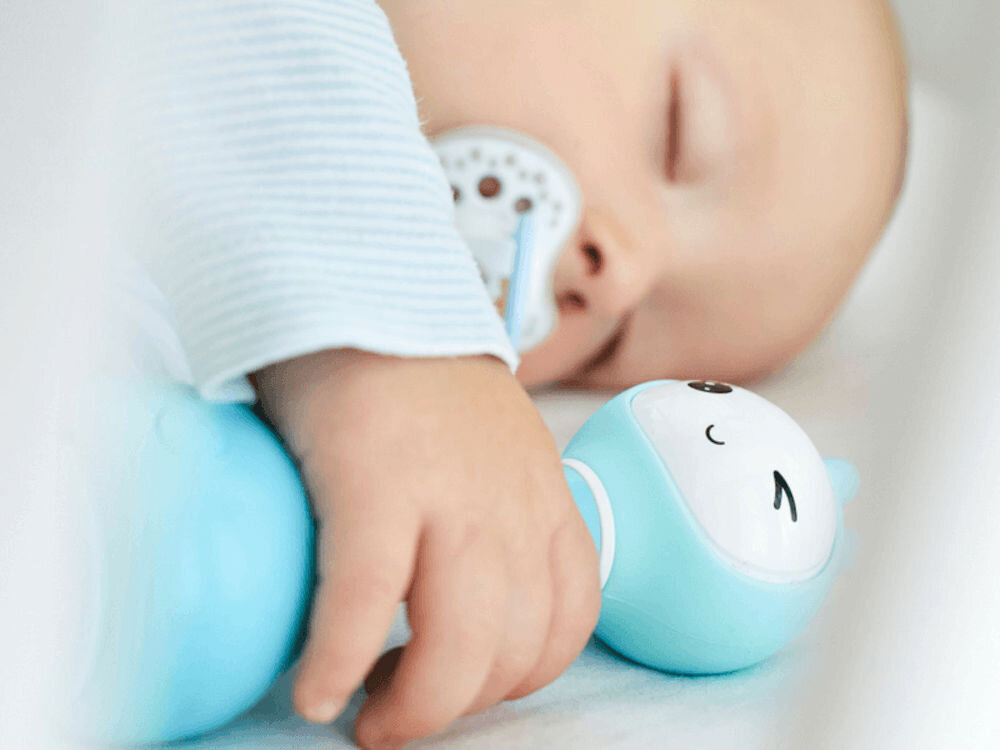 Zabawka edukacyjna ALILO Smarty Bunny R1 Niebieski kojące dźwięki, fabrycznie wgrane kołysanki, muzyka klasyczna oraz spokojne melodie, wspiera relaksację, budując zdrowe nawyki związane z odpoczynkiem,
					dziecko śpiące z zabawką w dłoni