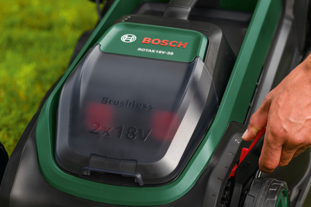 Zbliżenie na kosiarkę akumulatorową z widocznym logo BOSCH i napisem ROTAK 18V-38. Na obudowie znajduje się tekst \'Brushless 2x18V\'.