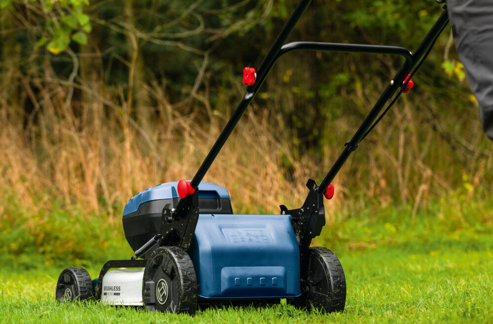 Kosiarka akumulatorowa BOSCH Professional GRA18V2-46SP 06008C8200 trawnik kosiarka na trawniku widoczna tyłem bez kosza w tle krzewy wydajna pielęgnacja trawnika pielęgnacja dużych trawników zasilanie akumulatorowe