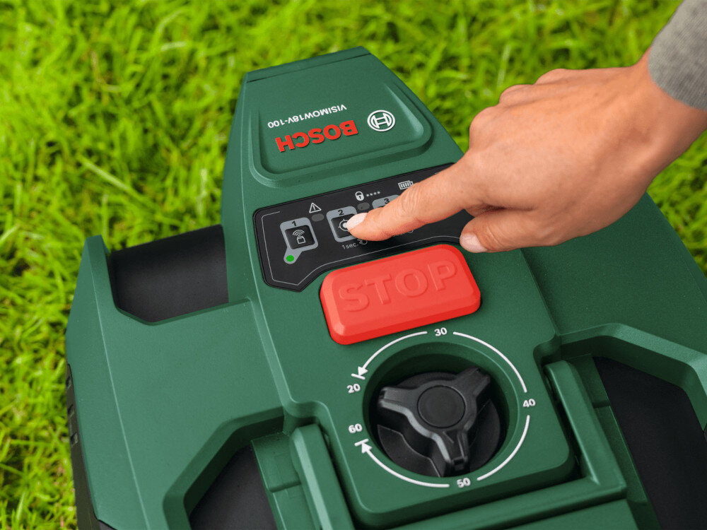 Robot koszący  BOSCH Visimow 18V-100 06008E1001 Bez przewodu ograniczającego ogród trawnik robot stoi na trawniku osoba dotyka palcem jednego z przycisków funkcyjnych funkcja SpotMow dokładne koszenie wybranych fragmentów trawnika możesz szybko poprawić wygląd wybranej części ogrodu bez konieczności uruchamiania pełnego cyklu pracy zwiększające precyzję i efektywność pielęgnacji