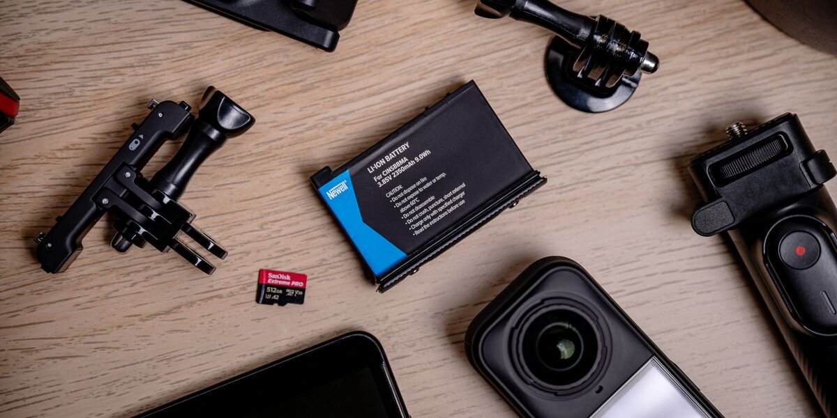 Akumulator NEWELL 2350 mAh Cinsbbma do Insta360 X4, Czarna bateria Newell, karta pamięci SanDisk oraz akcesoria montażowe do kamer sportowych na jasnym blacie, nagranie, akumulator, zasilanie, adapter