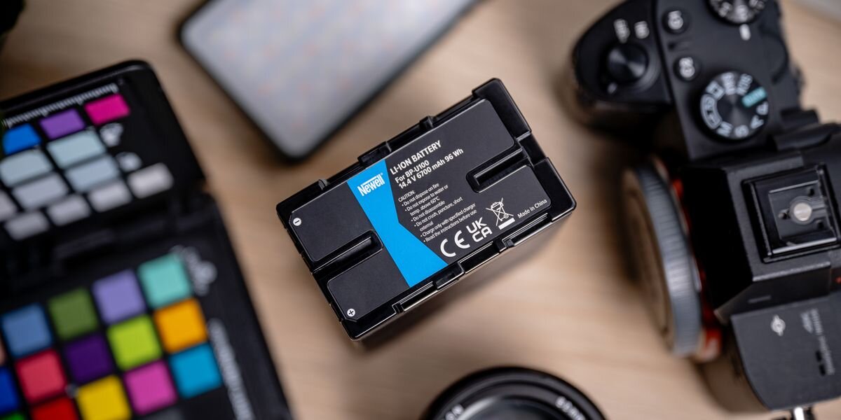 Akumulator NEWELL 6700 mAh BP-U100 do Sony, Spód akumulatora BP-U100 z niebieską etykietą Newell, parametrami 14,4 V, 6700 mAh oraz stykami montażowymi, 6700mAh, 96Wh, 14,4V, reportaże