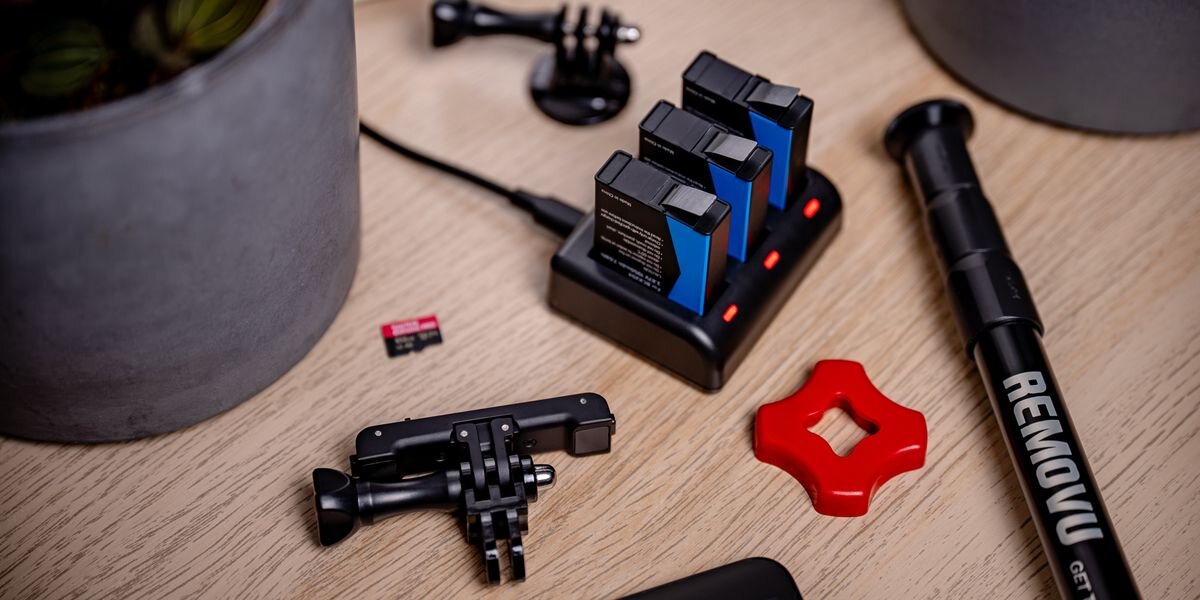 Ładowarka trzykanałowa NEWELL SDC-USB-C + 3 akumulatory BCX-204 do DJI Osmo Action, Trzy akumulatory ustawione w ładowarce, świecą czerwone diody, wokół uchwyty i akcesoria, kompatybilność, kamera, stabilność, działanie