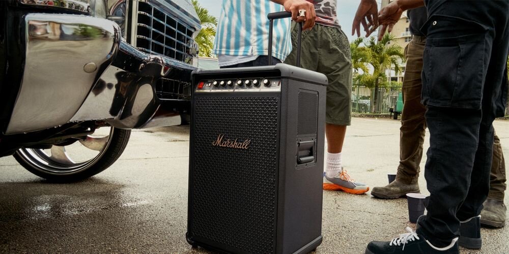 Power Audio MARSHALL Bromley 750 mobilny głośnik imprezowy 360 stopni True Stereophonic mocne brzmienie, głośnik stojący na ziemi, osoby stojące obok głośnika