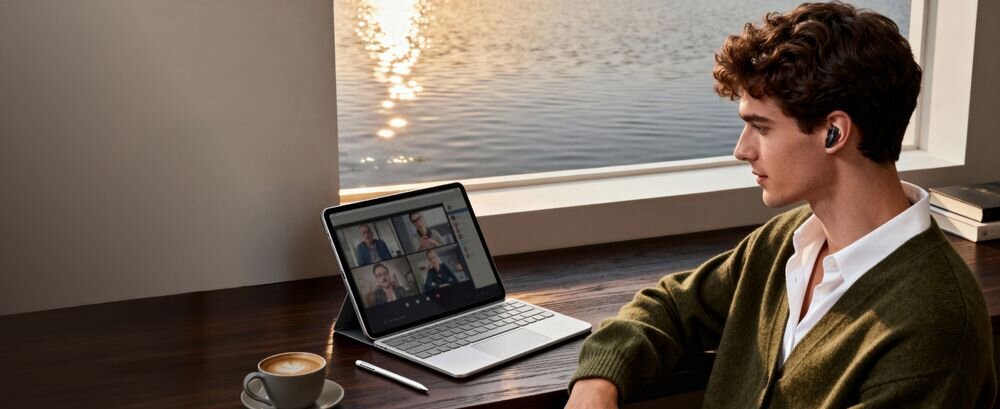 Słuchawki douszne SOUNDCORE Liberty Buds ANC LDAC 990 kb/s Android jakość audio, osoba z założonymi słuchawkami siedząca przy laptopie