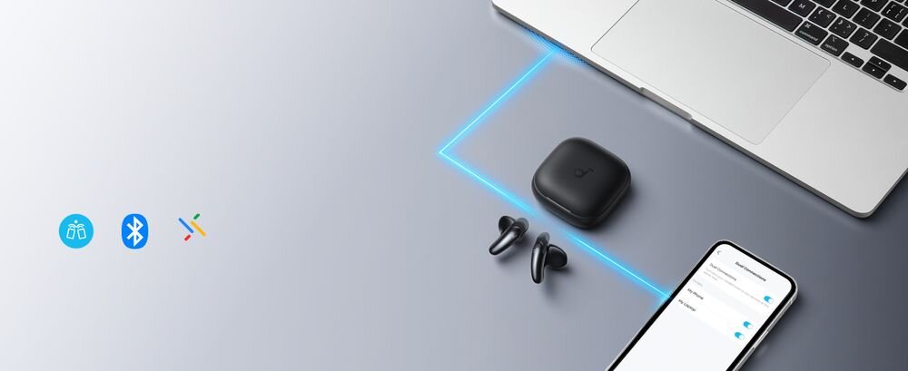 Słuchawki douszne SOUNDCORE Liberty Buds ANC multipoint Google Fast Pair, smartfon, etui oraz słuchawki leżące obok laptopa