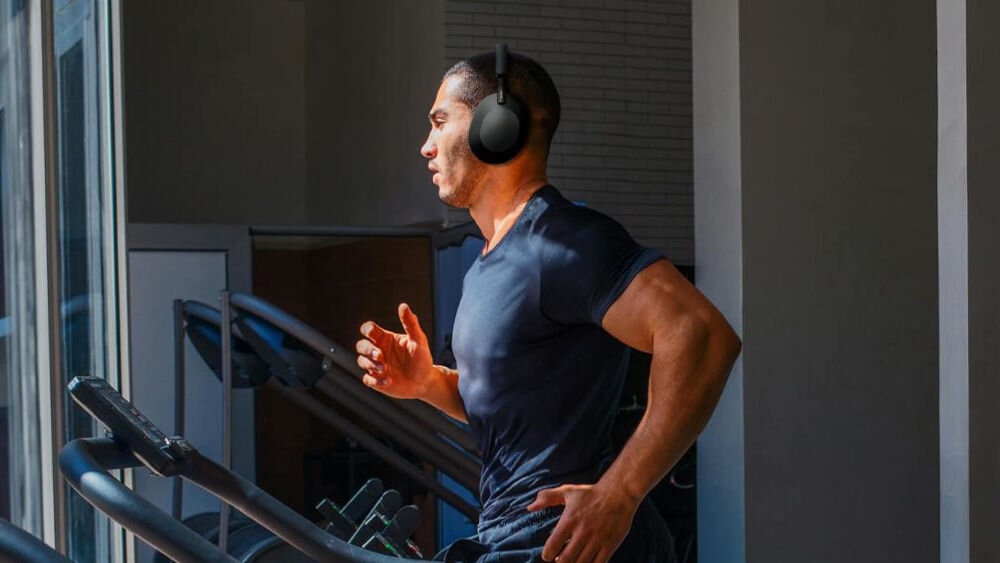 Słuchawki nauszne SONY WH-1000XM5SA z funkcją Auto NC Optimizer i redukcją hałasu, osoba z założonymi słuchawkami nausznymi biegająca na bieżni