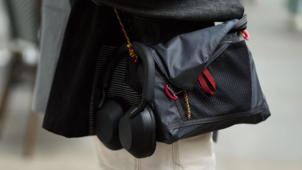 Słuchawki nauszne SONY WH-1000XM5SA z baterią 30h i etui transportowym, słuchawki przewieszone obok torby