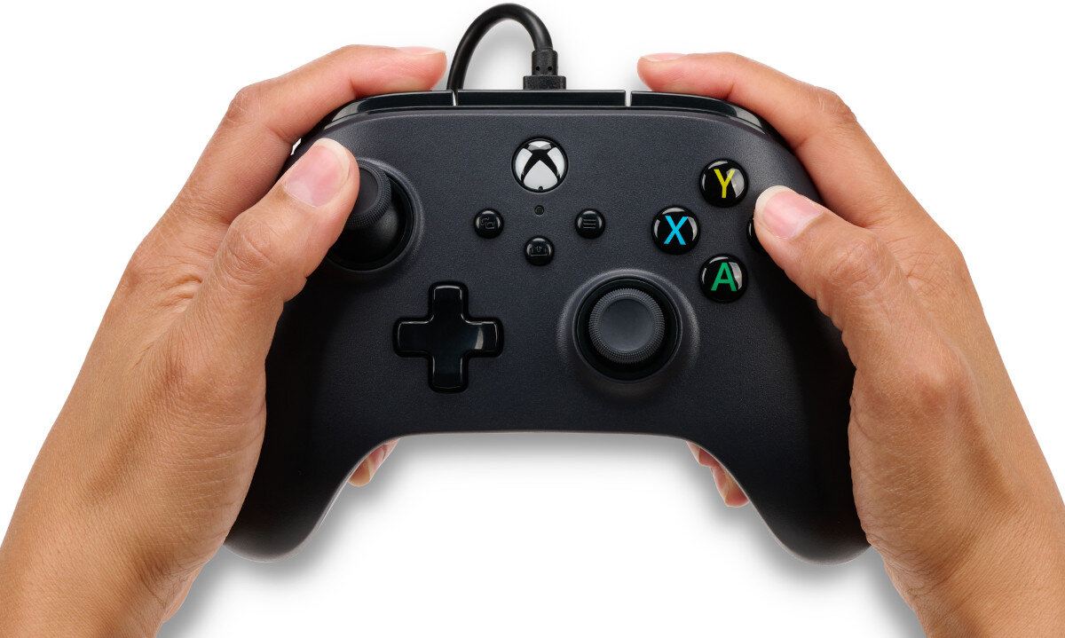 Osoba trzyma czarny kontroler do gier z widocznymi przyciskami oznaczonymi literami Y, X, B, A oraz logo Xbox.