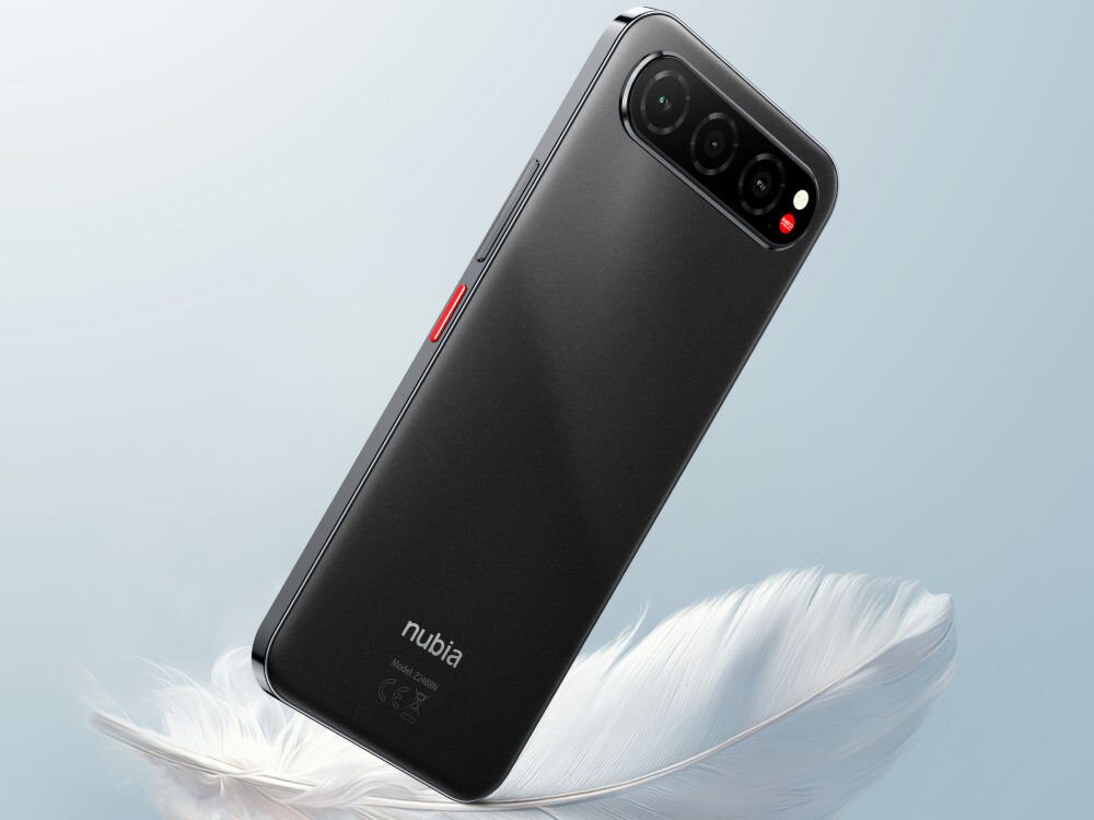 Smartfon NUBIA Air 8/256GB 6.78 120Hz Smartfon nubia w kolorze czarnym, z potrójnym modułem aparatu ułożonym poziomo, leży na dużym, białym piórze. Widać czerwony akcent w module aparatu i logo nubia z tyłu telefonu.