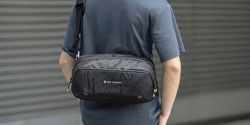 Zbliżenie na mokrą torbę K&F Concept Urban Wander 17 zwisającą na plecach mężczyzny w szarym T-shircie