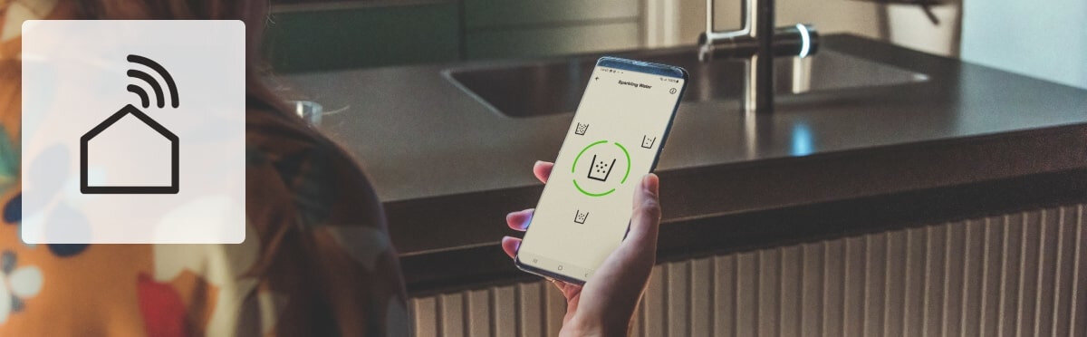 BATERIA FRANKE MYTHOS WATER HUB ALL IN ONE Smartfon sterujący systemem przy zlewie z ikoną domu Wi‑Fi. Zdalne zarządzanie aplikacja mobilna kontrola zużycia wody monitoring baterii
