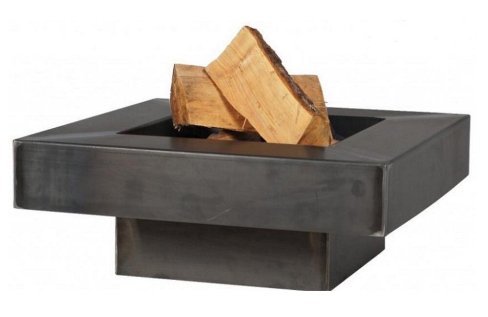 Na obrazie widoczne jest metalowe palenisko ogrodowe o kwadratowym kształcie z drewnem ułożonym na środku. Palenisko ma prostą, nowoczesną konstrukcję i ciemny kolor.