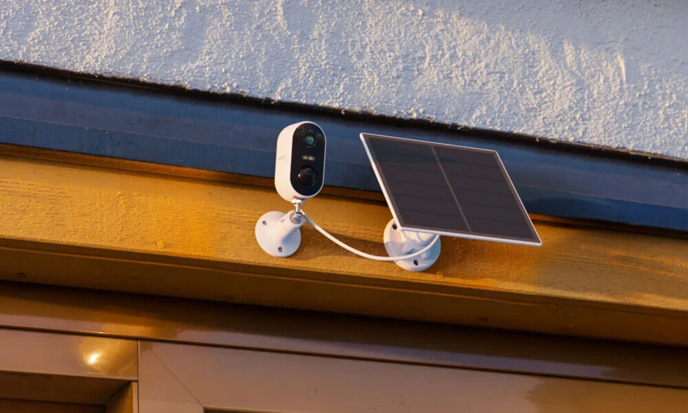 Kamera ARENTI GO1T Zewnętrzna, Wi-Fi + Panel solarny Na brązowej belce pod dachem domu przymocowana jest kamera Arenti. Obok niej znajduje się panel solarny. odporność IP65 zakres temperatury pracy od –10°C do +50°C port USB-C wymiary 95 × 50 × 52 mm waga 190 g