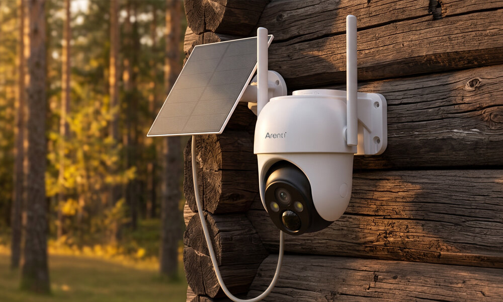 Kamera ARENTI GO2T Zewnętrzna, Wi-Fi, Kamera obrotowa + Panel solarny Na ścianie z drewnianych bali zamontowana jest kamera Arenti. Obok widać panel solarny na tle rozmytego lasu. Wbudowany mikrofon głośnik dwukierunkową komunikację głosową karcie microSD o pojemności do 256 GB w chmurze Wi-Fi 2,4 GHz Android oraz iOS