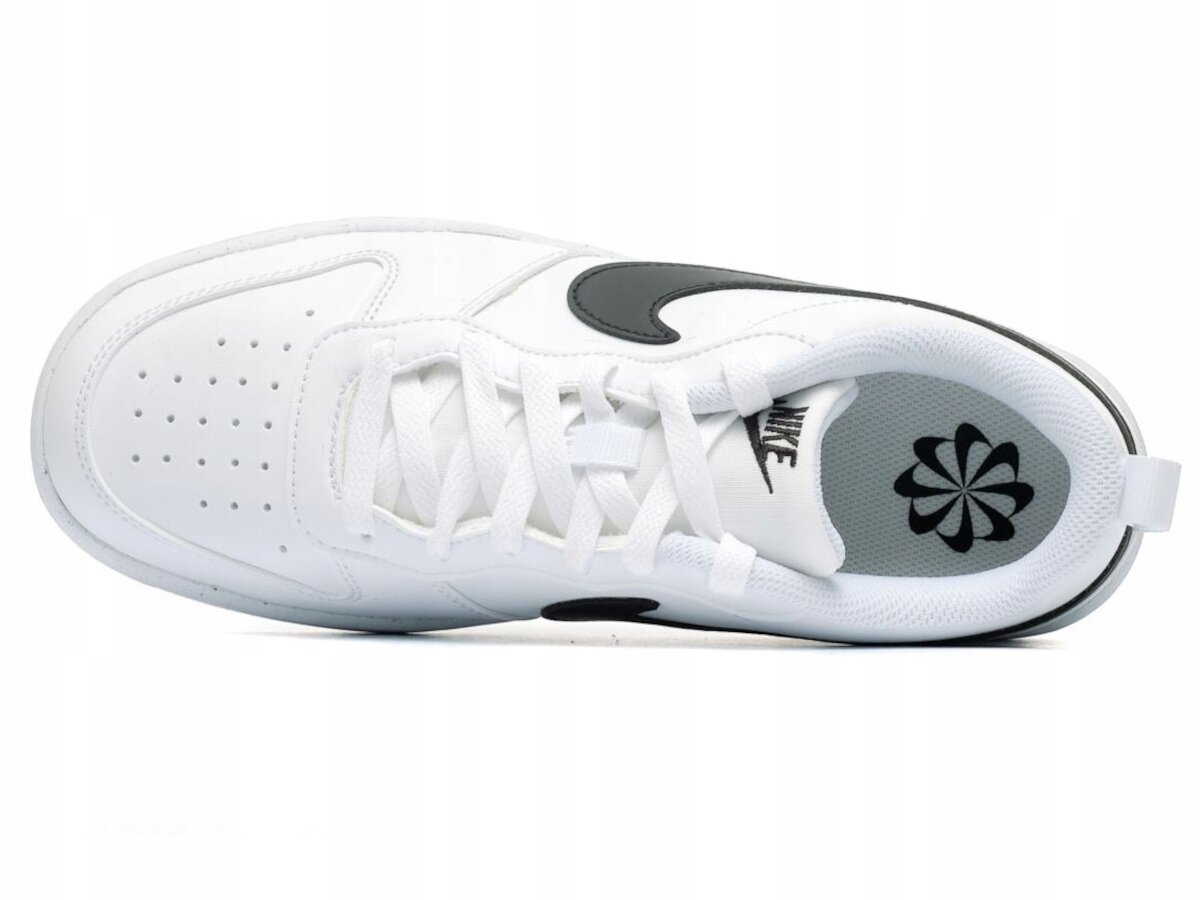 Biały sportowy but z czarnym logo w kształcie łuku na boku. Wkładka wewnętrzna ma czarny wzór przypominający kwiat oraz napis \'NIKE\'.