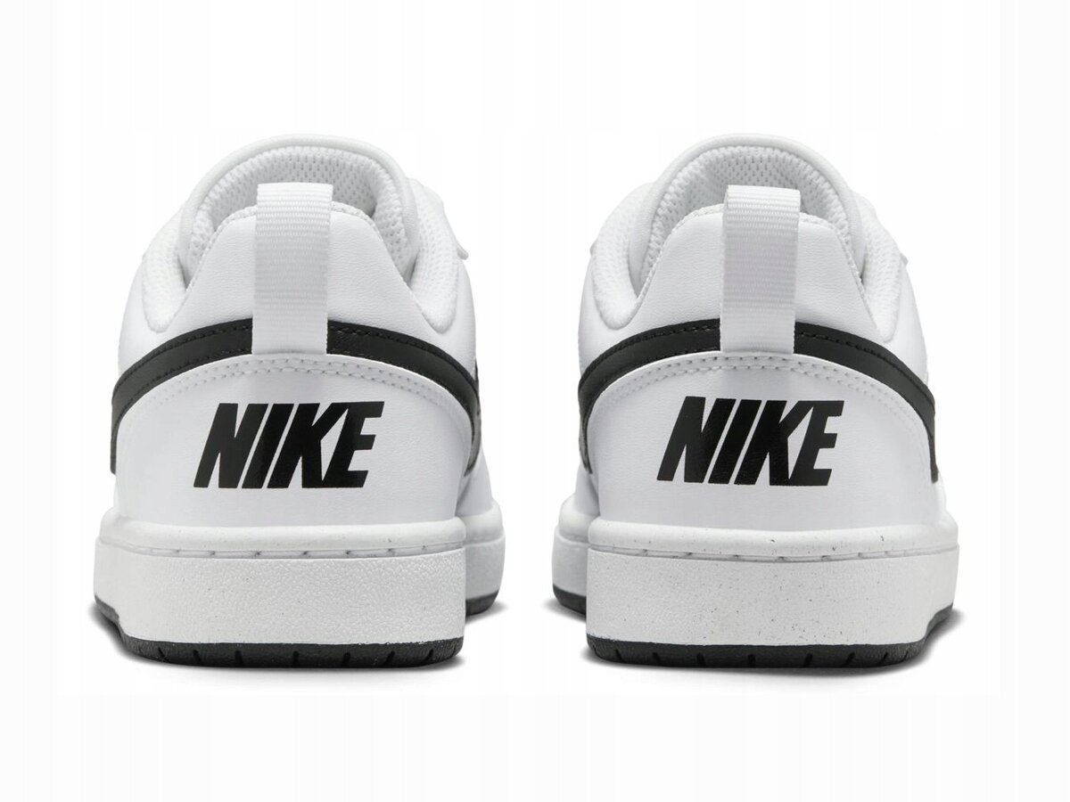 Zdjęcie przedstawia tył dwóch białych butów sportowych z czarnym napisem \'NIKE\' na pięcie. Buty mają czarny pasek biegnący wzdłuż pięty.
