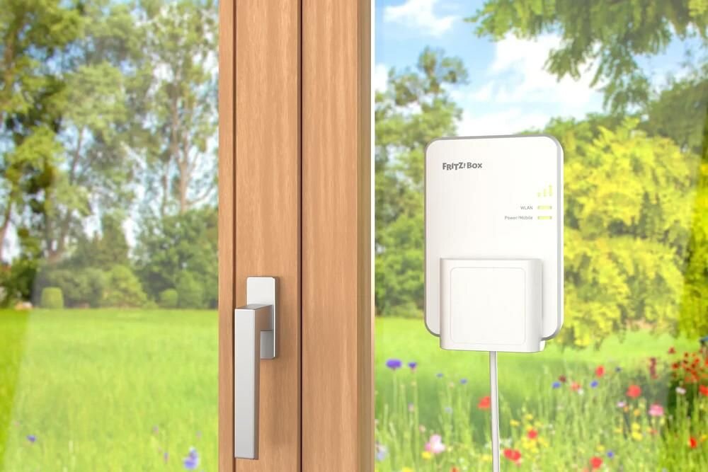 Repeater FRITZ!Box z Wi‑Fi zamontowany przy oknie poprawia zasięg sieci bezprzewodowej w domowym otoczeniu