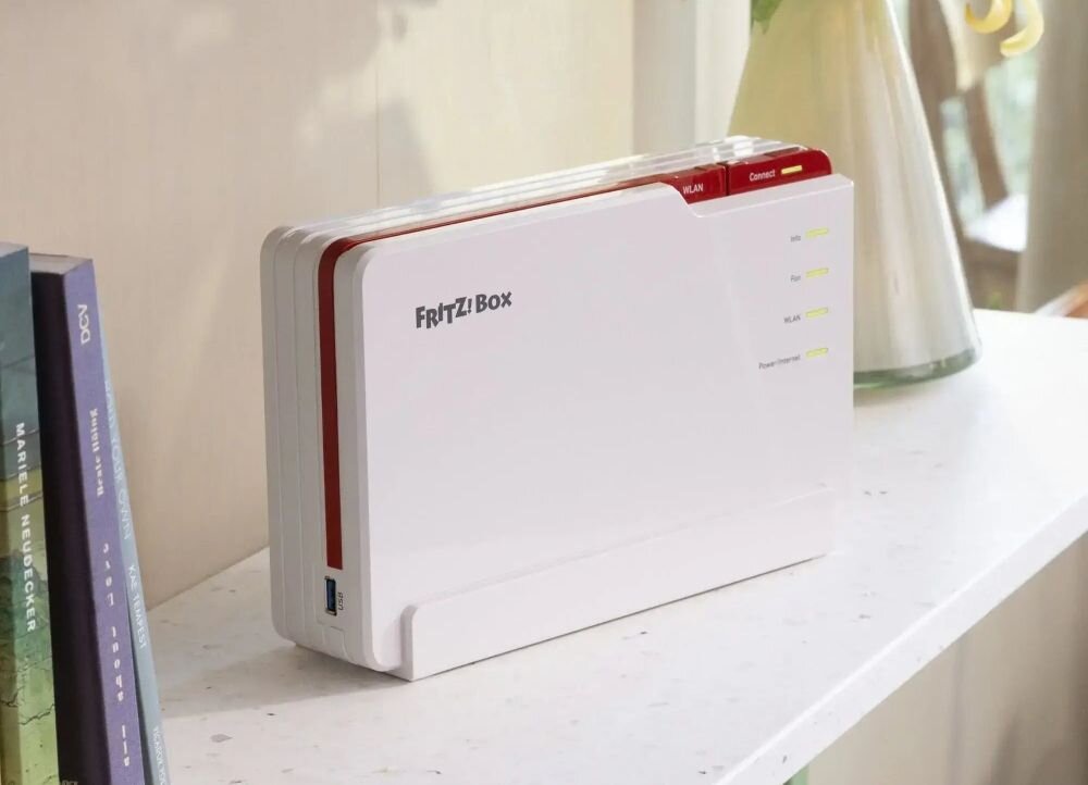 Router FRITZ!Box z Wi‑Fi 7 stoi na półce przy oknie, rozszerzając zasięg sieci bezprzewodowej w domu