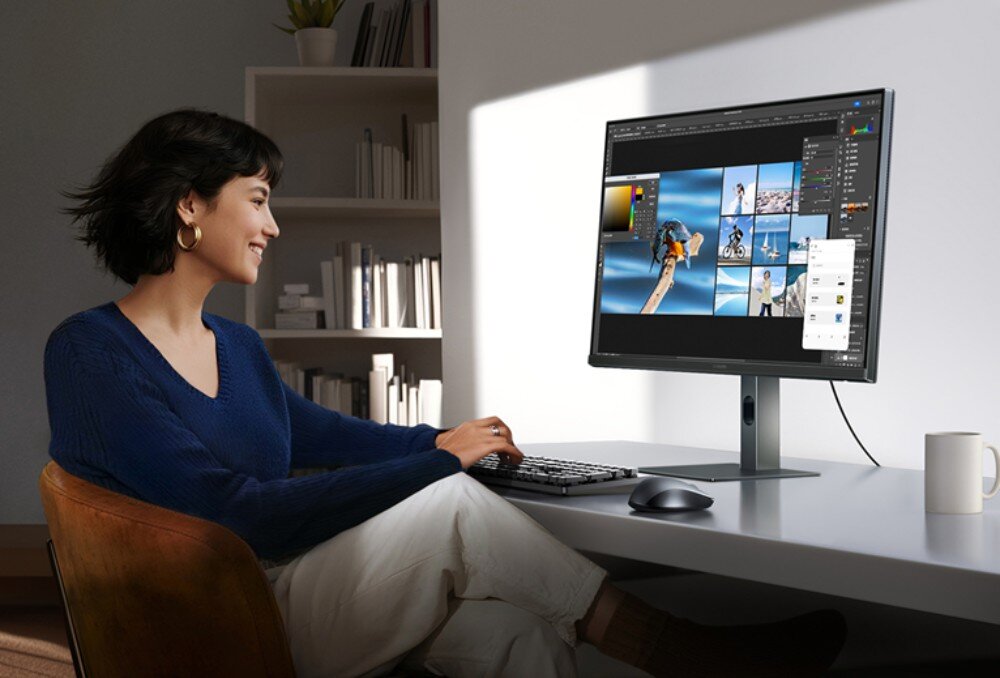 Monitor XIAOMI A27QI 2026 Kobieta siedząca przy białym biurku pracuje na komputerze stacjonarnym używając klawiatury i myszki przed włączonym monitorem, ochrona wzroku
