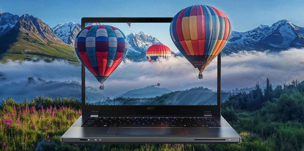 Laptop z otwartym ekranem, na którym wyświetlany jest obraz górskiego krajobrazu z balonami na tle nieba. Logo \'acer\' widoczne na dolnej ramce ekranu.
