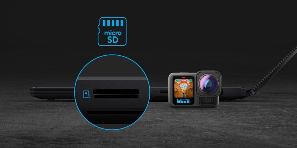 Obraz przedstawia laptop z widocznym gniazdem na kartę microSD oraz kamerę sportową obok. Nad gniazdem znajduje się ikona z napisem \'micro SD\'.