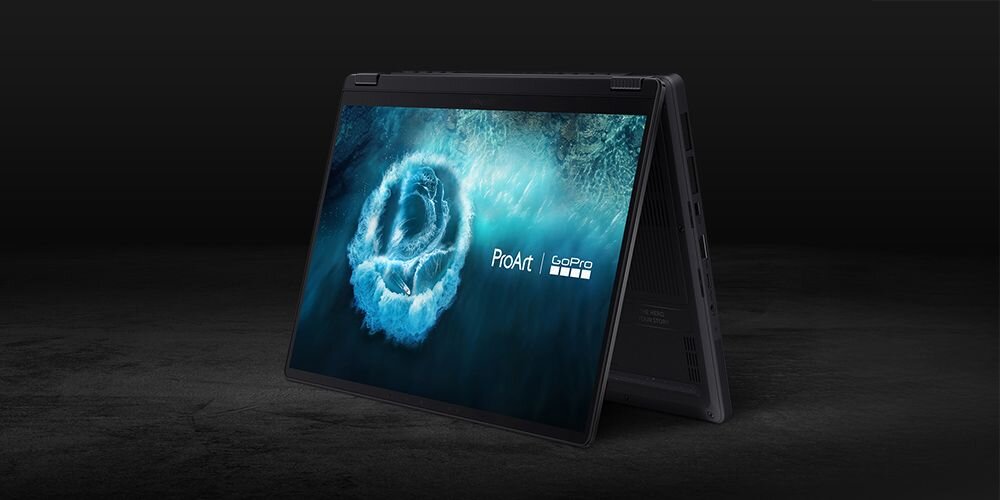 Laptop w trybie namiotu z wyświetlaczem pokazującym niebieską grafikę z logo \'ProArt GoPro\'. Obudowa jest ciemna, a ekran zajmuje większość widocznej powierzchni.