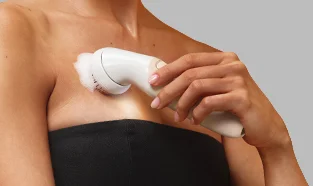 Kobieta używająca szczotki peelingującej do przygotowania skóry przed depilacją.