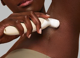 Kobieta depilująca nogę białym depilatorem Braun Silk·épil 9 Flex na jasnym tle.