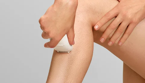 Zbliżenie nogi z depilatorem Braun Silk·épil 5 przykładanym do skóry.