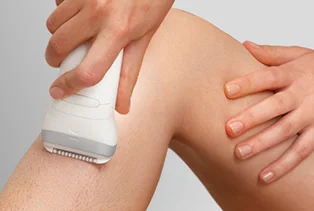 Kobieta depilująca nogę depilatorem Braun Silk·épil 7.