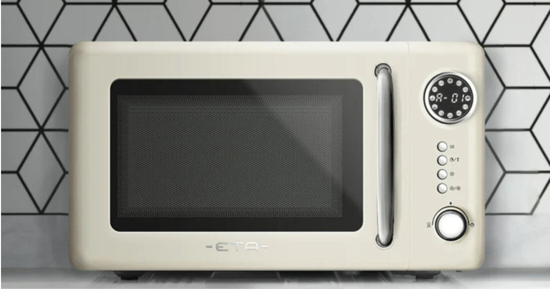 Beżowa kuchenka mikrofalowa z okrągłym panelem sterowania i srebrnym uchwytem. Na froncie widoczne jest logo \'ETA\'.